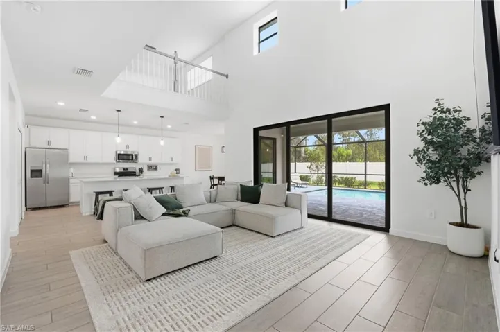 Open-concept living area featuring high vaulted ceilings and wood-finish flooring