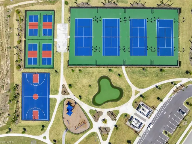 Community recreation area featuring three tennis courts, four pickleball courts, a full basketball court, a playground with shade structures, and a central green space with a decorative pond