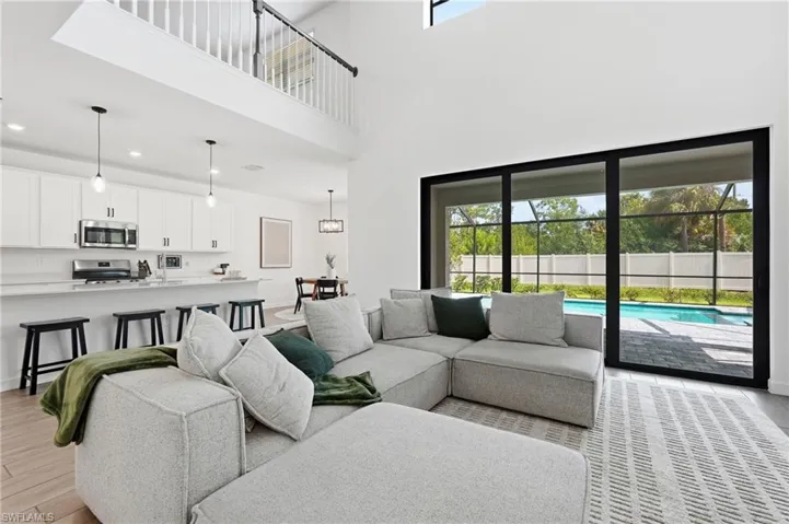Spacious open-concept living area featuring high ceilings and wood-finish flooring