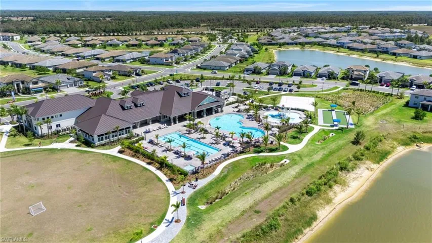Spacious community amenity center featuring multiple swimming pools, a sports court, and a large recreational field