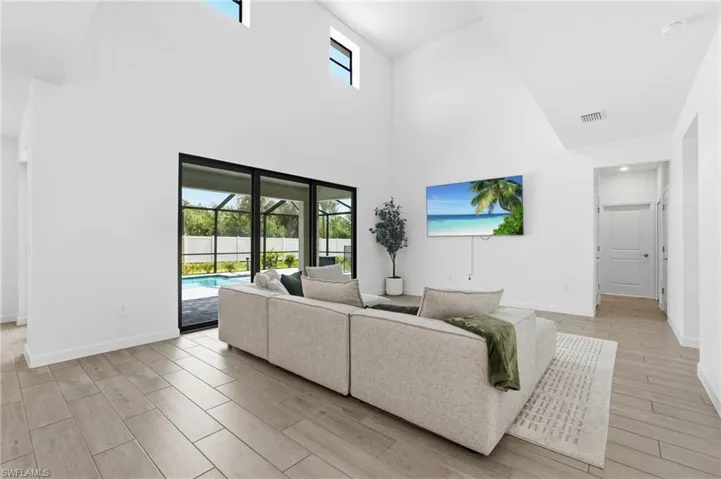 Spacious living area featuring high vaulted ceilings and abundant natural light