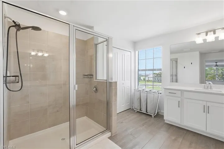 Shower enclosure with glass panels, beige wall tiling, and an integrated shower system