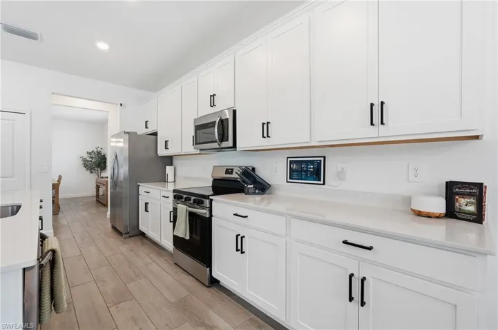 Contemporary kitchen with white shaker-style cabinetry and matte black hardware