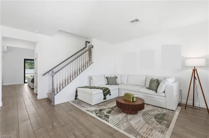 Bright living area with wood-finish flooring extending into a hallway