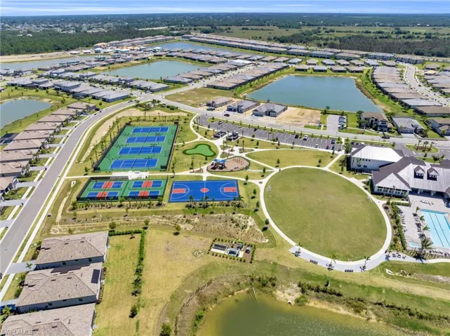 Aerial perspective of a planned residential community featuring multiple lakes, extensive recreational facilities, and a large central green space