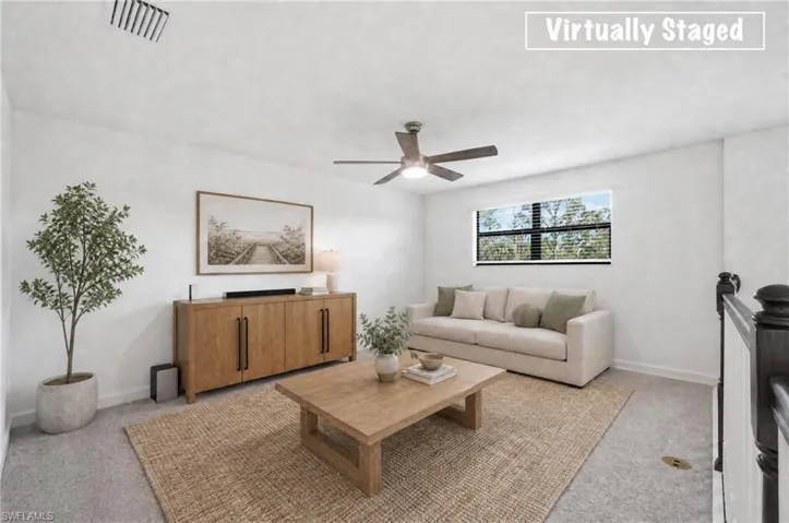 Spacious room featuring light-toned walls, a single window with horizontal blinds, overhead ceiling fan with lighting, and carpet flooring