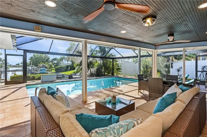 Lanai patio area with lounge area under roof with ceiling fans.