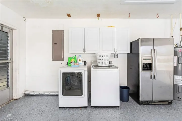 Washer, dryer and second refrigerator in the garage with epoxy coated floors.