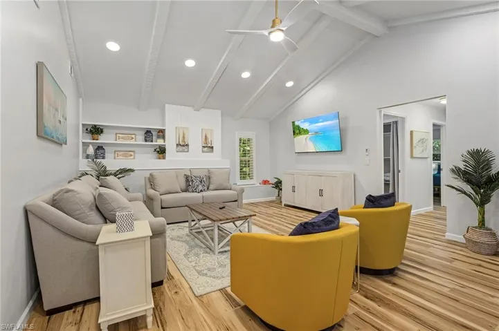 Great room with cathedral ceilings and sliders to the pool area.