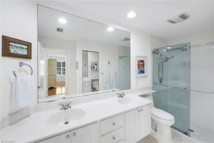 Full bath featuring double vanity, a newly installed barn door shower, comfort height toilet light  and recessed lighting