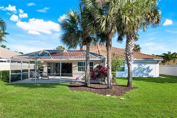 Rear view of house with a tile roof, screen enclosure, dinning area and a patio