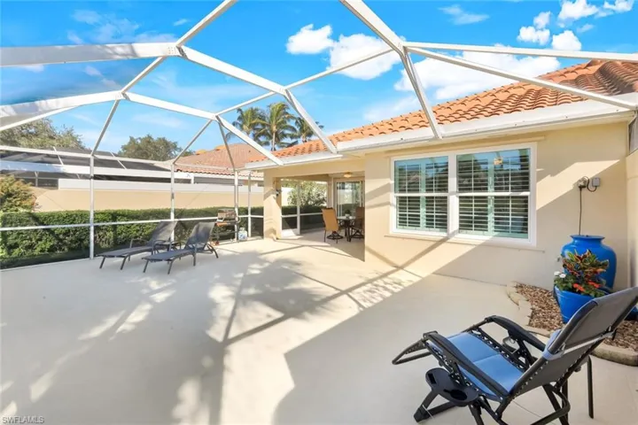 View of lanai with covered dinning area, peaceful water fountain feature and large entertainment area of screened lanai.