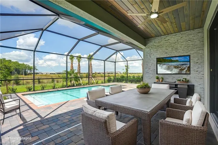 View of patio / terrace featuring ceiling fan, an outdoor pool, and a lanai