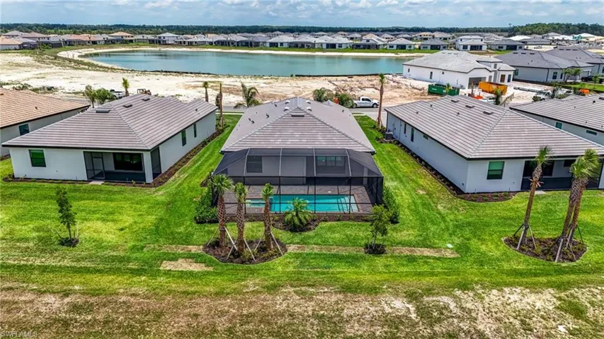Aerial perspective of suburban area with a large body of water and a pool area
