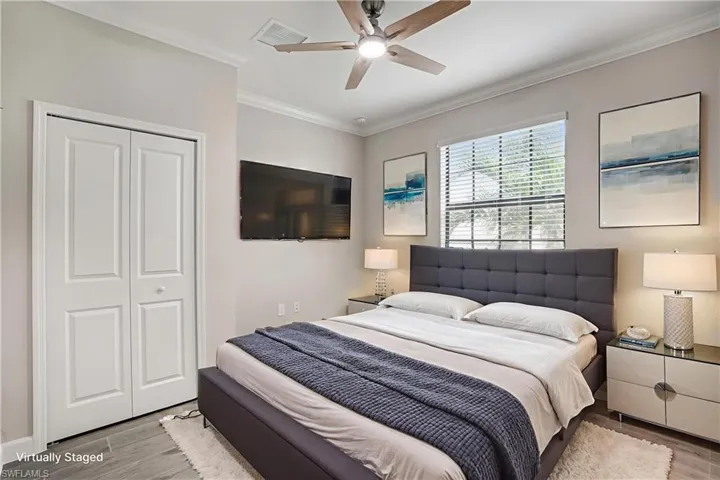 Bedroom featuring wood finished floors, ornamental molding, a closet, and a ceiling fan