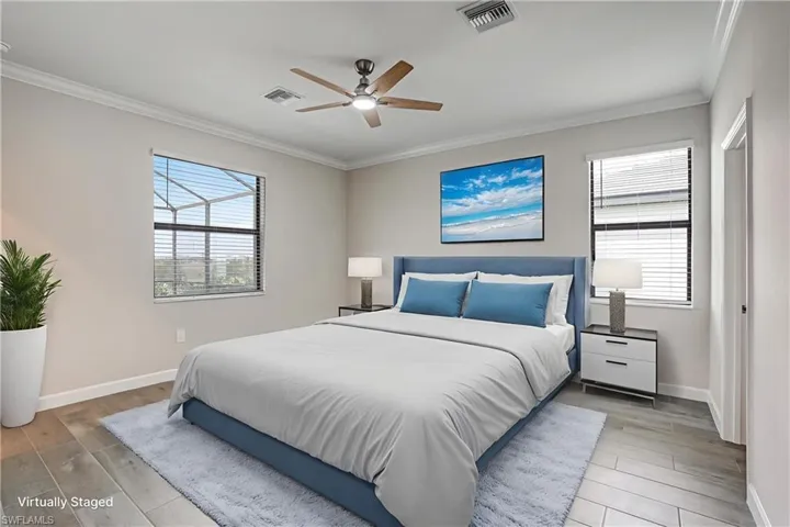 Bedroom with crown molding, baseboards, light wood-type flooring, and ceiling fan