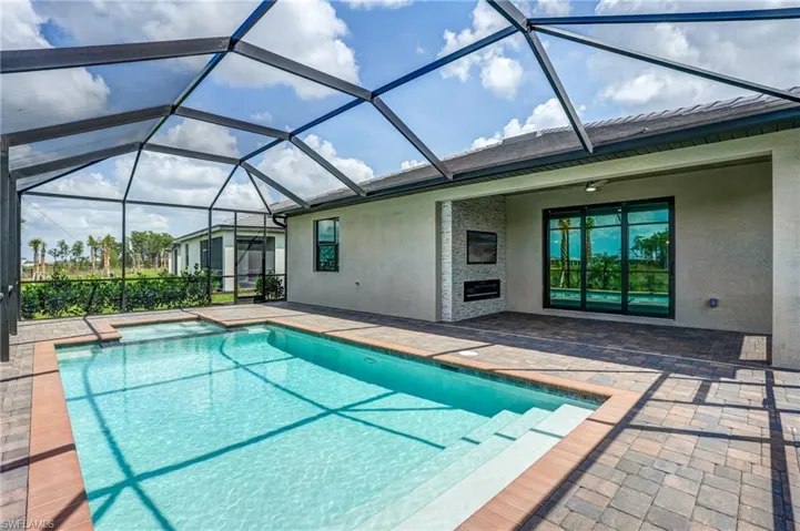 Swimming pool with a patio area and glass enclosure