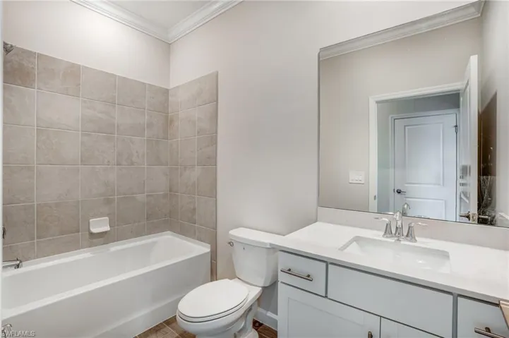 Full bathroom featuring ornamental molding, vanity, toilet, and bathing tub / shower combination