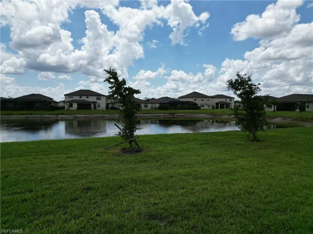 Expansive green lawn bordering a tranquil pond