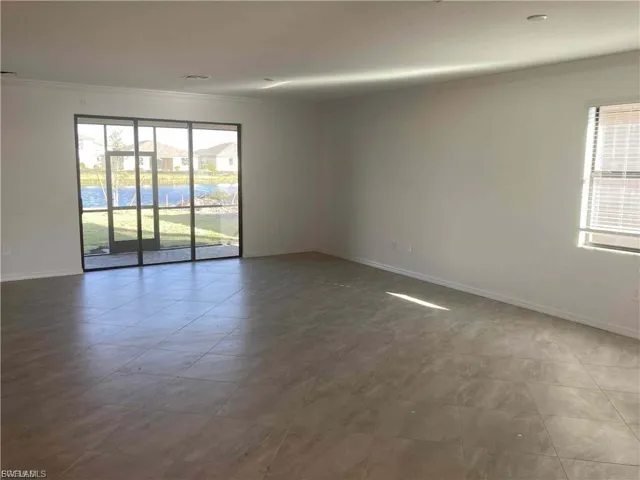 Expansive room featuring large format tile flooring, neutral wall tones, and recessed lighting
