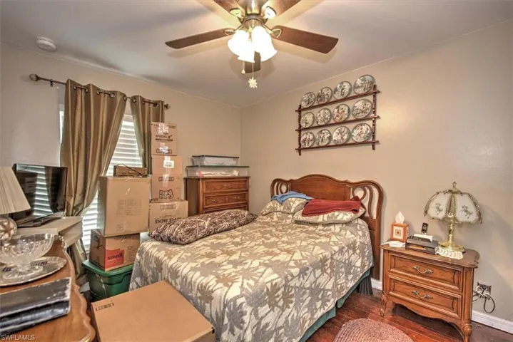 Bedroom with multiple windows, ceiling fan, and dark hardwood / wood-style floors