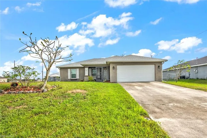 View of front of property featuring a garage and a front yard