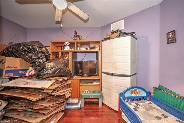 Den featuring dark wood-type flooring and ceiling fan