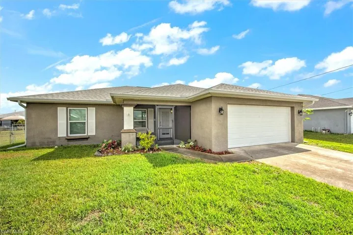 View of front of home with a garage and a front yard