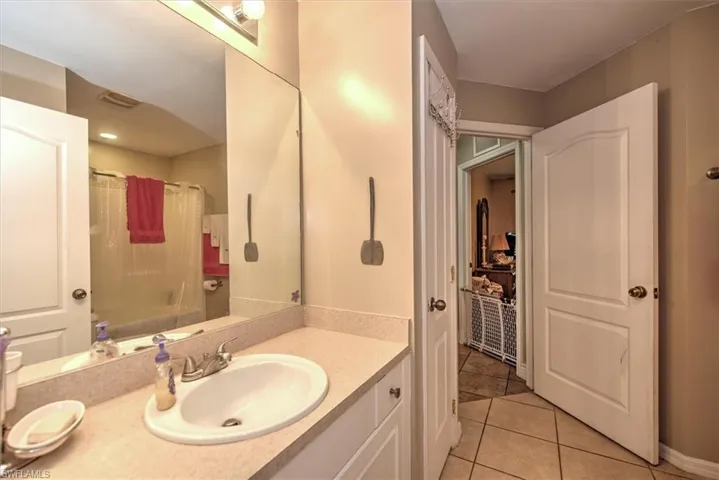 Bathroom featuring tile patterned flooring, vanity, and shower / bath combination with curtain