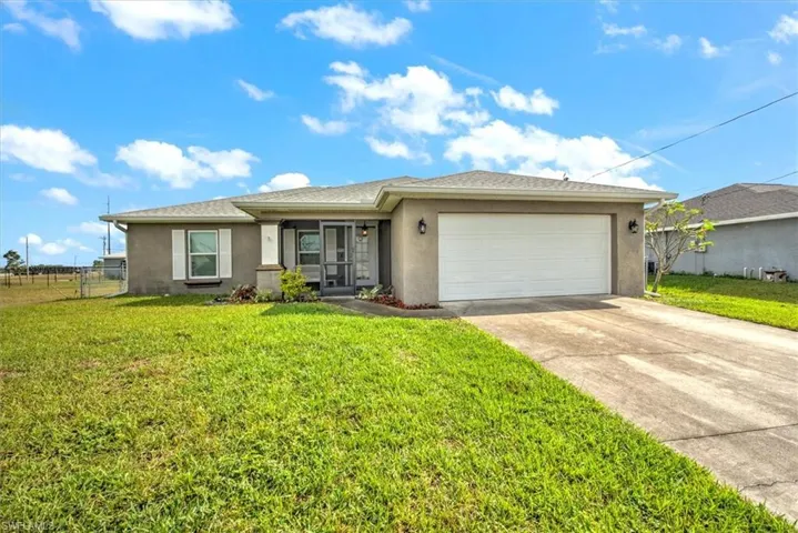View of front of house with a garage and a front lawn