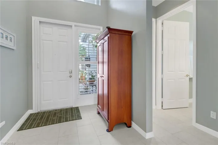 Entryway with baseboards and light tile patterned floors