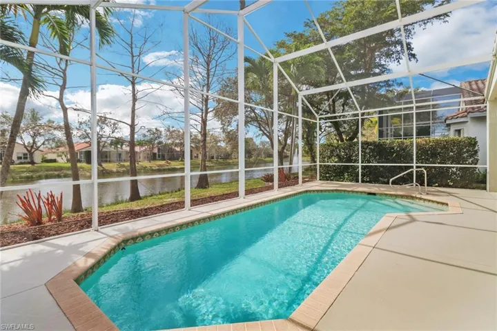 Outdoor pool with a lanai, a water view, and a patio area
