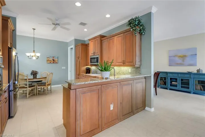 Kitchen featuring brown cabinets, stainless steel appliances, visible vents, and a peninsula