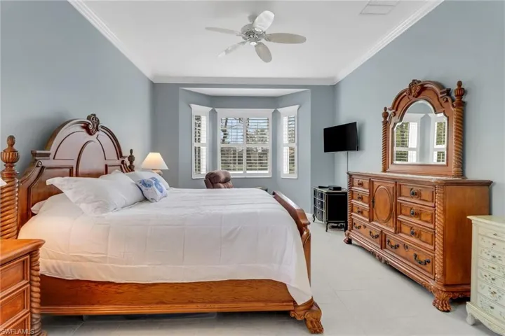 Bedroom featuring a ceiling fan, ornamental molding, and visible vents