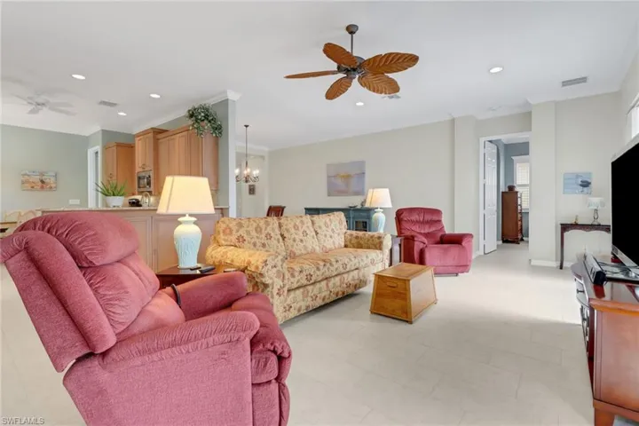 Living room featuring ceiling fan with notable chandelier, visible vents, and recessed lighting