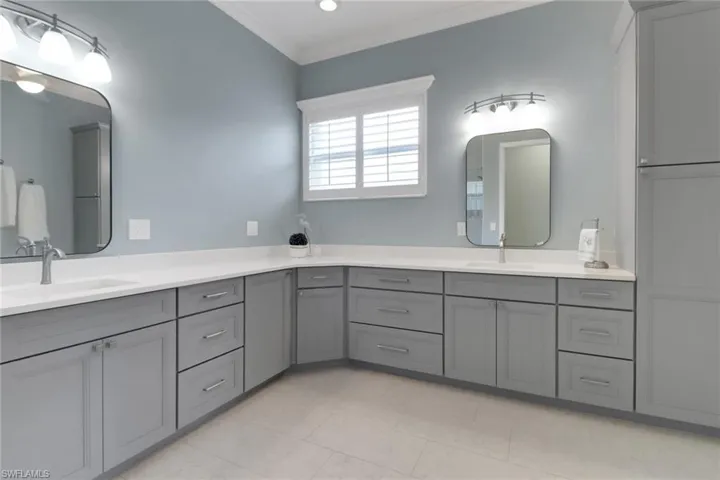 Full bathroom with double vanity, crown molding, a sink, and tile patterned flooring