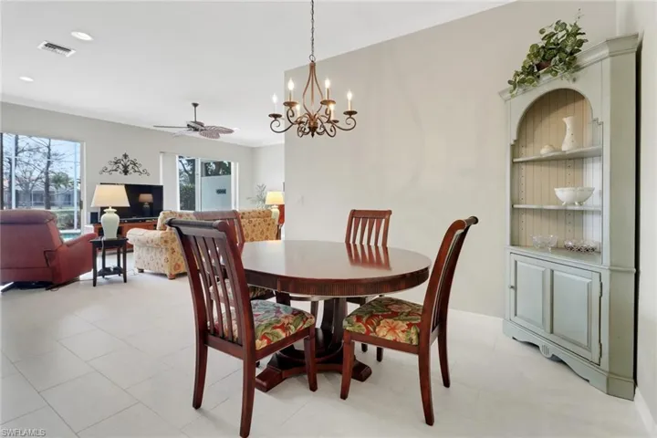 Dining area with built in features, ornamental molding, visible vents, recessed lighting, and ceiling fan with notable chandelier