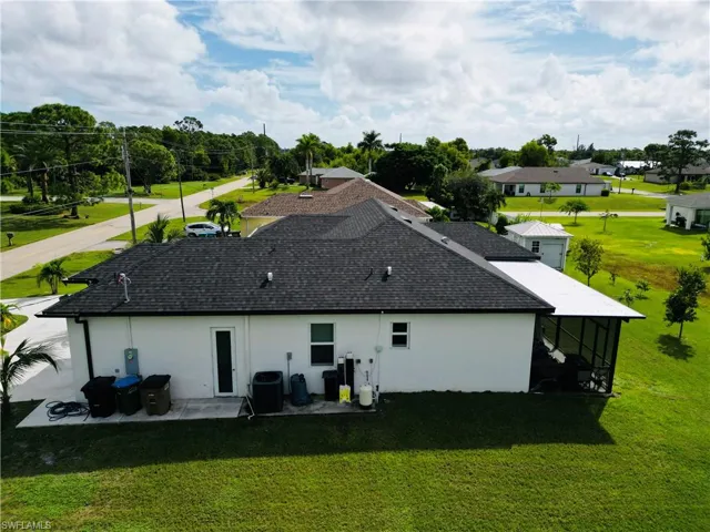 Rear view of house with a lawn, stucco siding, and a patio area