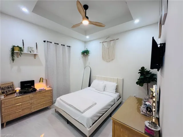 Bedroom featuring a raised ceiling and a ceiling fan