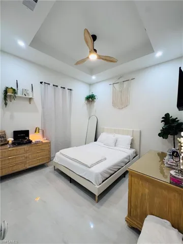 Bedroom featuring a tray ceiling, recessed lighting, and ceiling fan