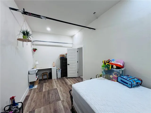 Bedroom with wood finished floors and baseboards