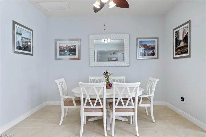 Neutral-toned tile flooring, light-colored walls, and a central ceiling fan with integrated lighting