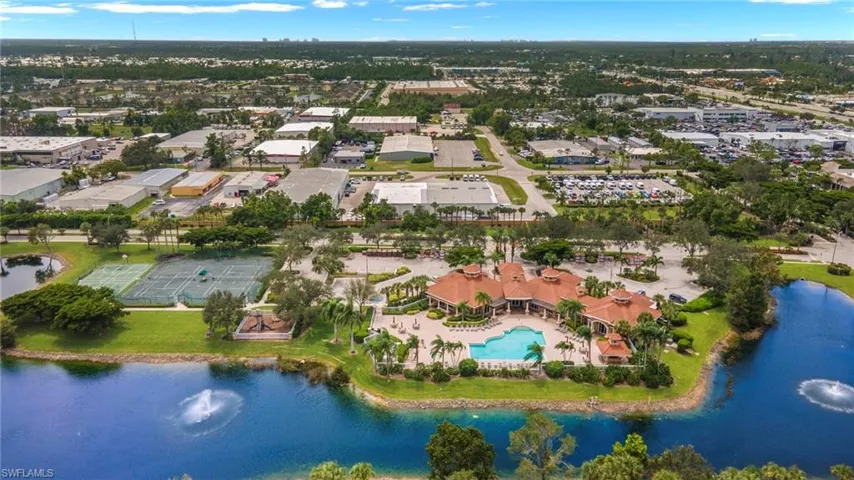 Aerial perspective of a multi-purpose complex featuring an outdoor swimming pool, tennis courts, water-feature ponds, and extensive hardscaped patio areas