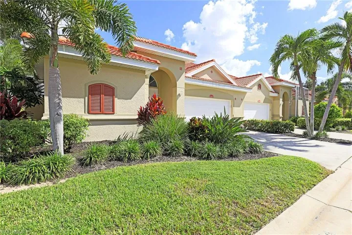 Stucco exterior featuring arched architectural detailing, tile roofing, decorative window shutters, and a multi-car garage