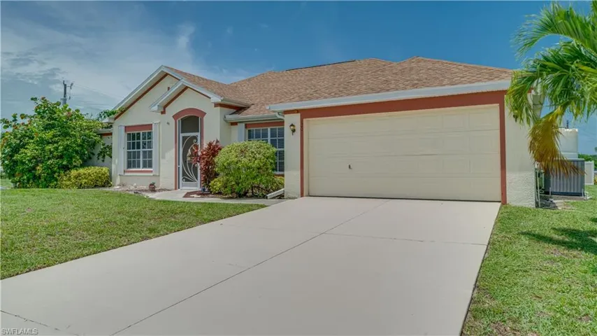 Ranch-style home featuring a front yard and a garage