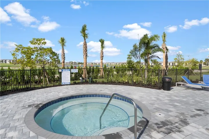 View of swimming pool featuring a hot tub and a patio area