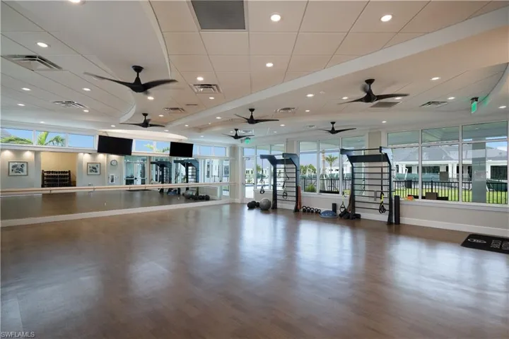 Exercise room featuring wood-type flooring and a drop ceiling