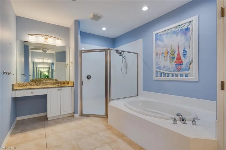 Full bathroom with vanity, a stall shower, light tile patterned floors, a bath, and recessed lighting