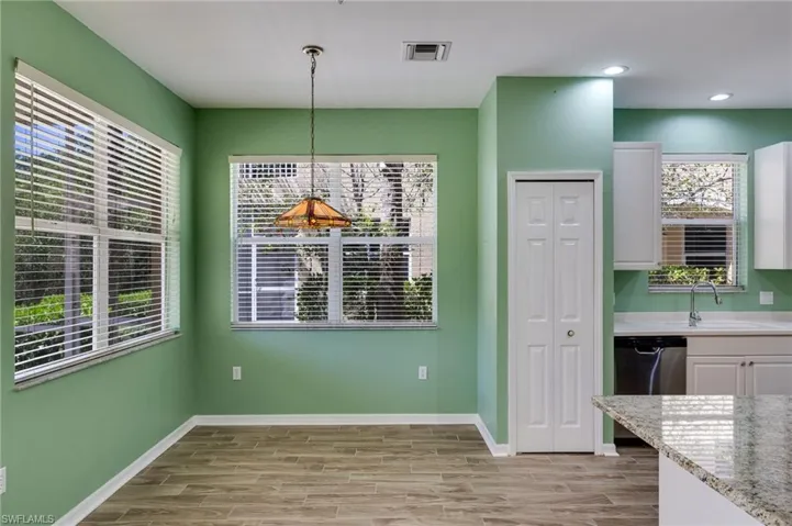 Unfurnished dining area with wood tiled floors and baseboards