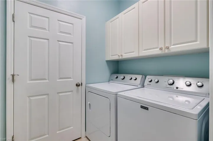 Laundry room with separate washer and dryer and cabinet space